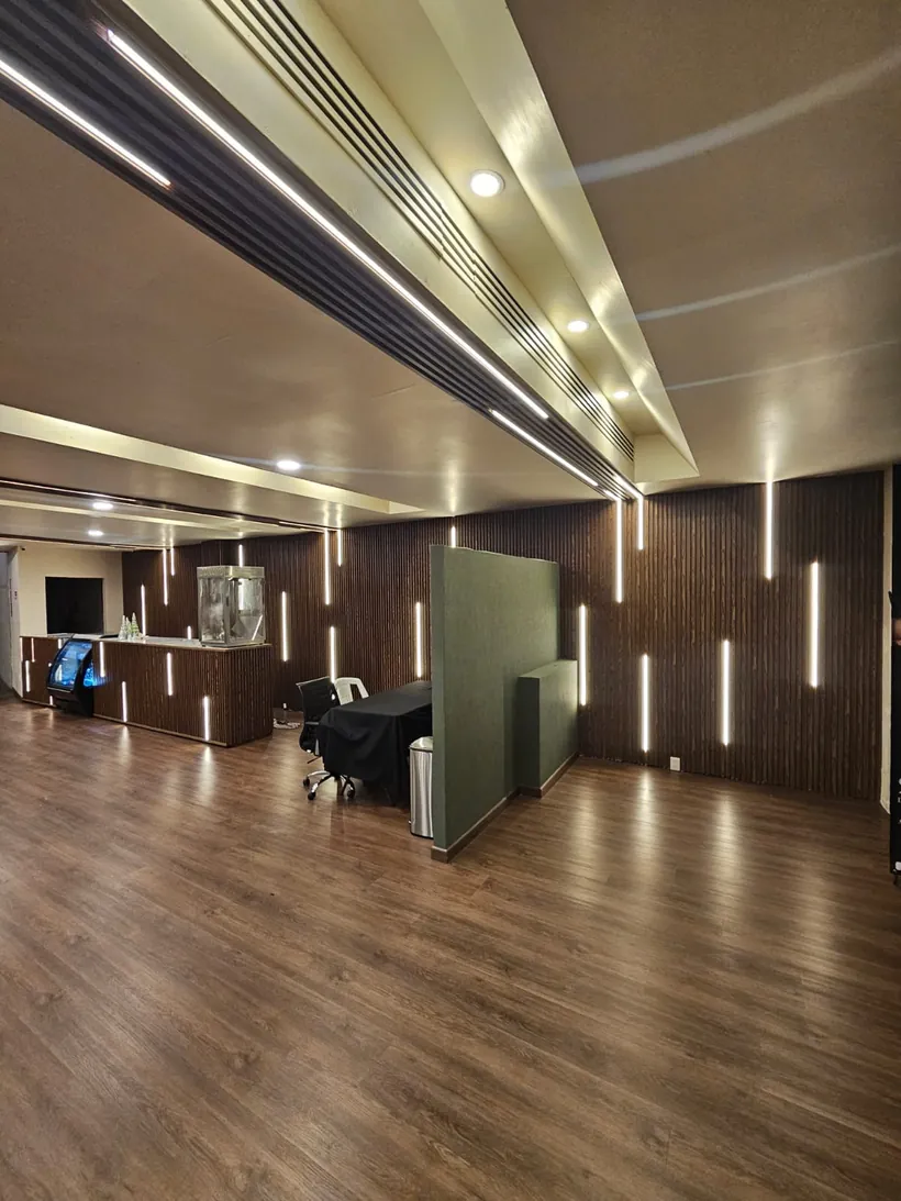Local con lambrín de madera y líneas de luz integradas
